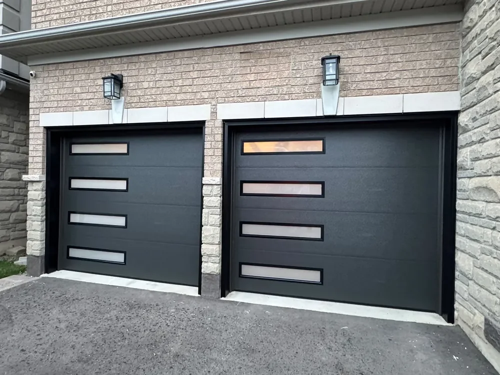 Black modern flush garage doors with slim glass strips on a home in Ajax