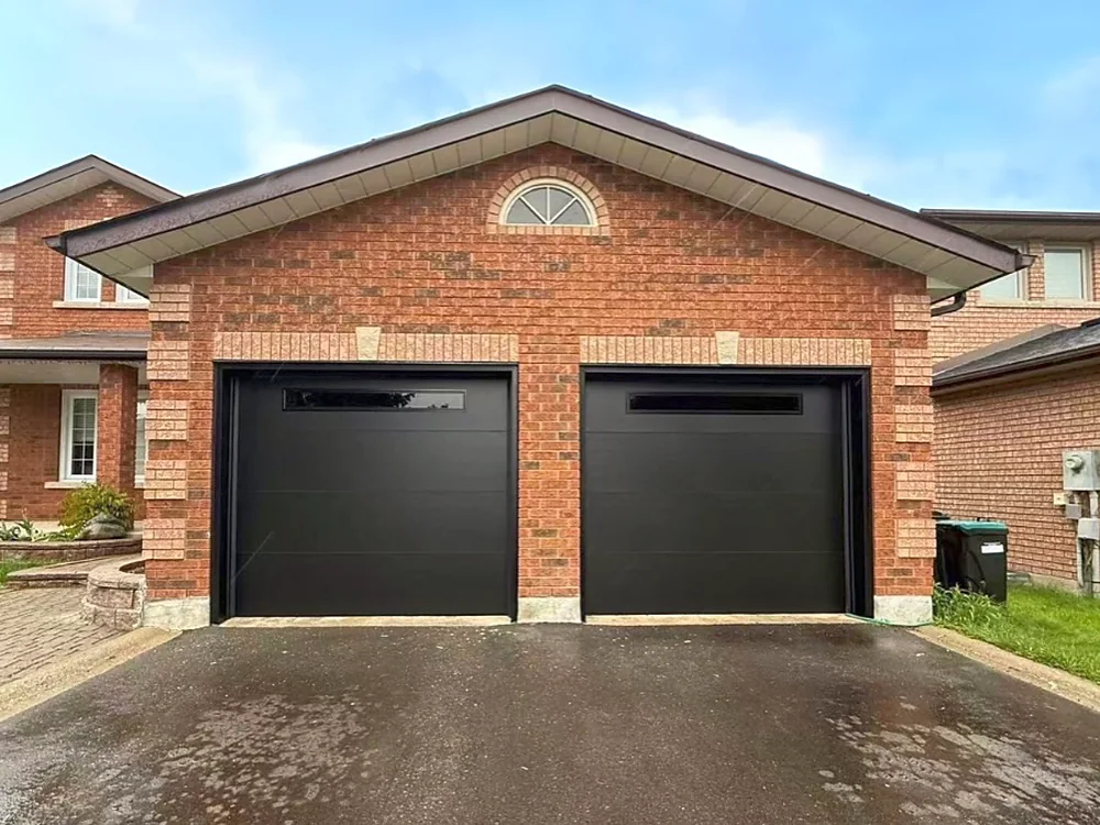 Black modern flush garage doors with slim glass strips on a home in Bradford