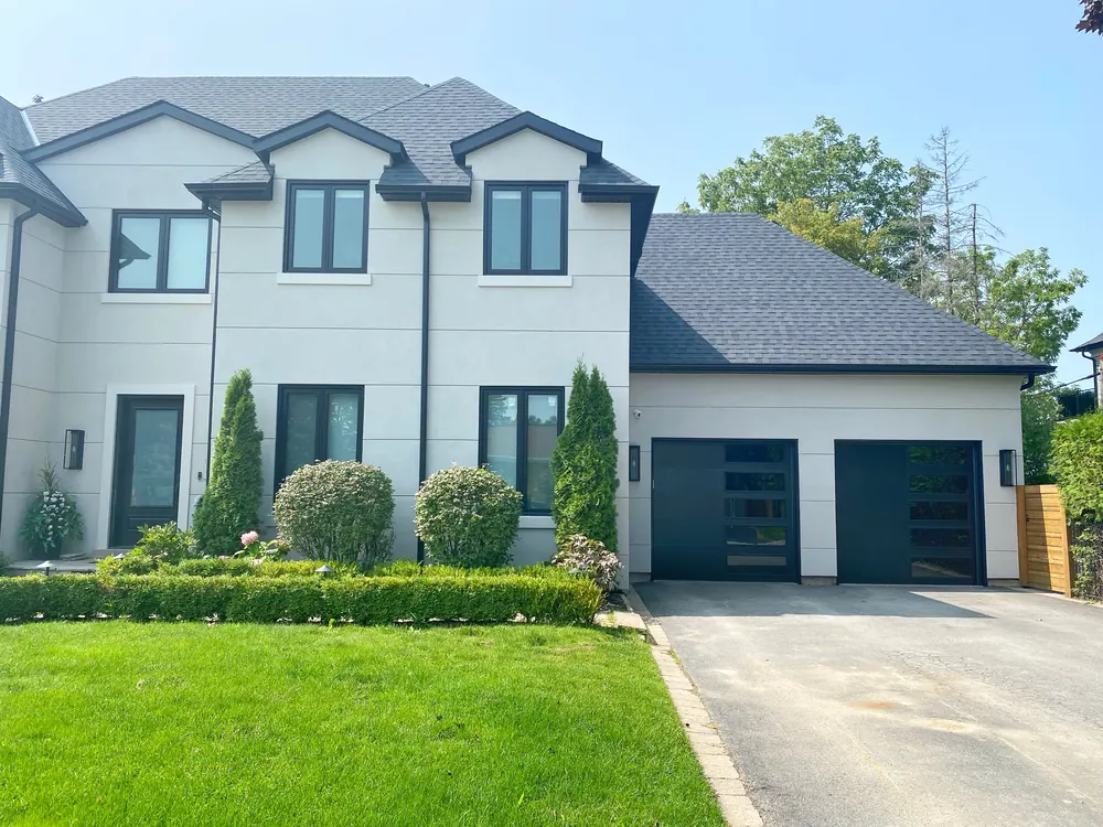 Black modern flush garage doors with windows on a home in King City