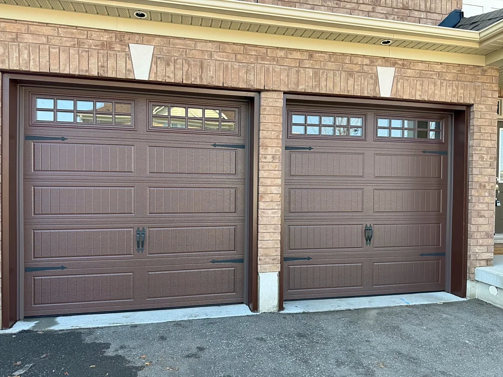 Chocolate brown carriage-house garage doors with windows on a home in Kleinburg