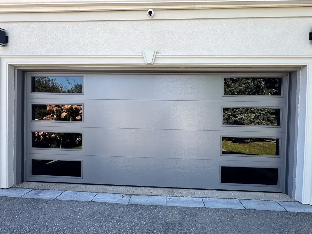 Grey modern flush garage door with windows on a home in Markham