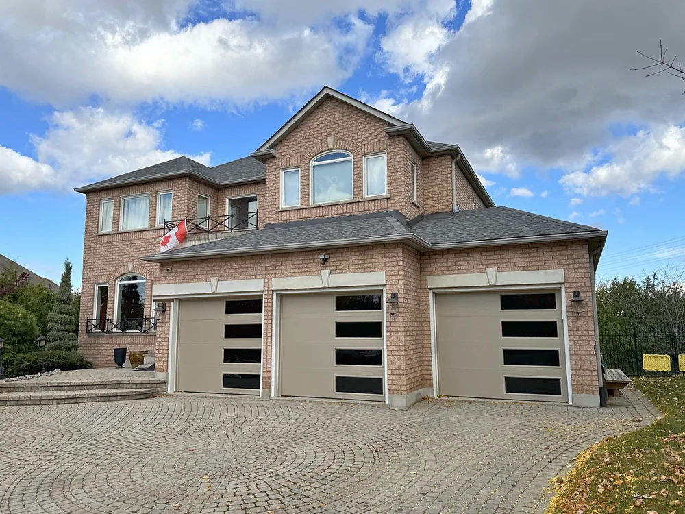 Sandstone modern flush garage doors with windows on a home in MARKHAM