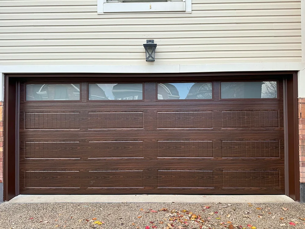 Woodgrain carriage-house garage door with windows on a home in Markham