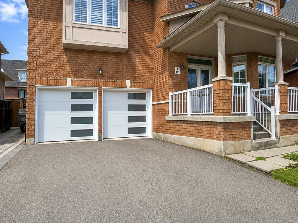White modern flush garage doors with windows on a home in Milton