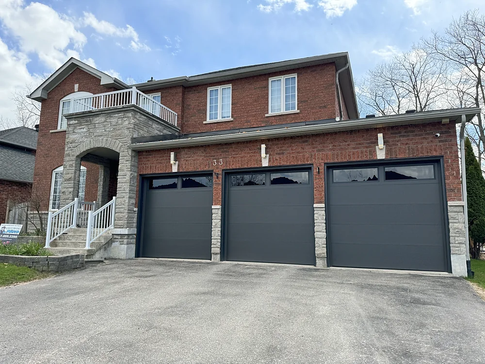 Black modern flush garage doors with windows on a home in Newmarket