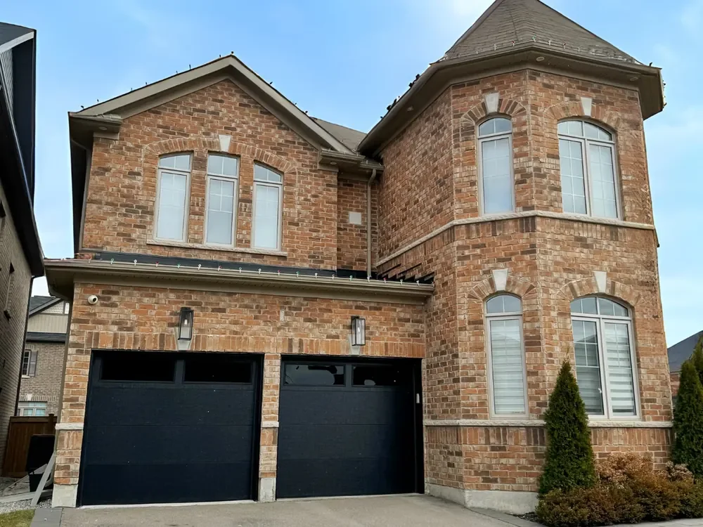 Black modern flush garage doors with windows on a home in Pickering