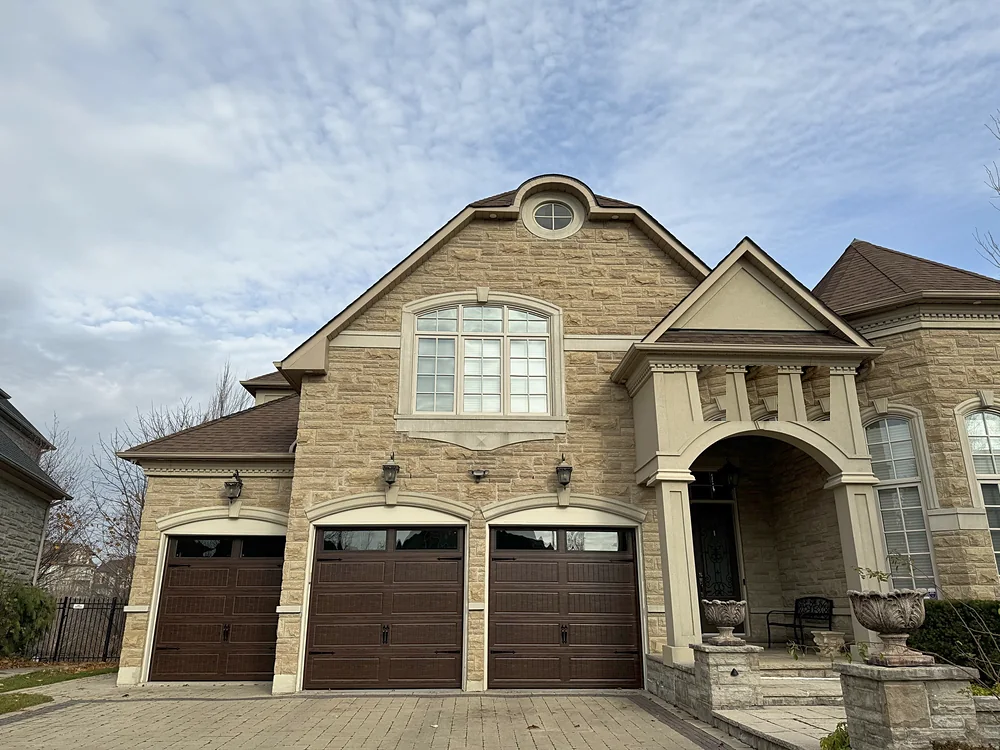 Woodgrain carriage-house garage doors with windows on a home in Richmond Hill