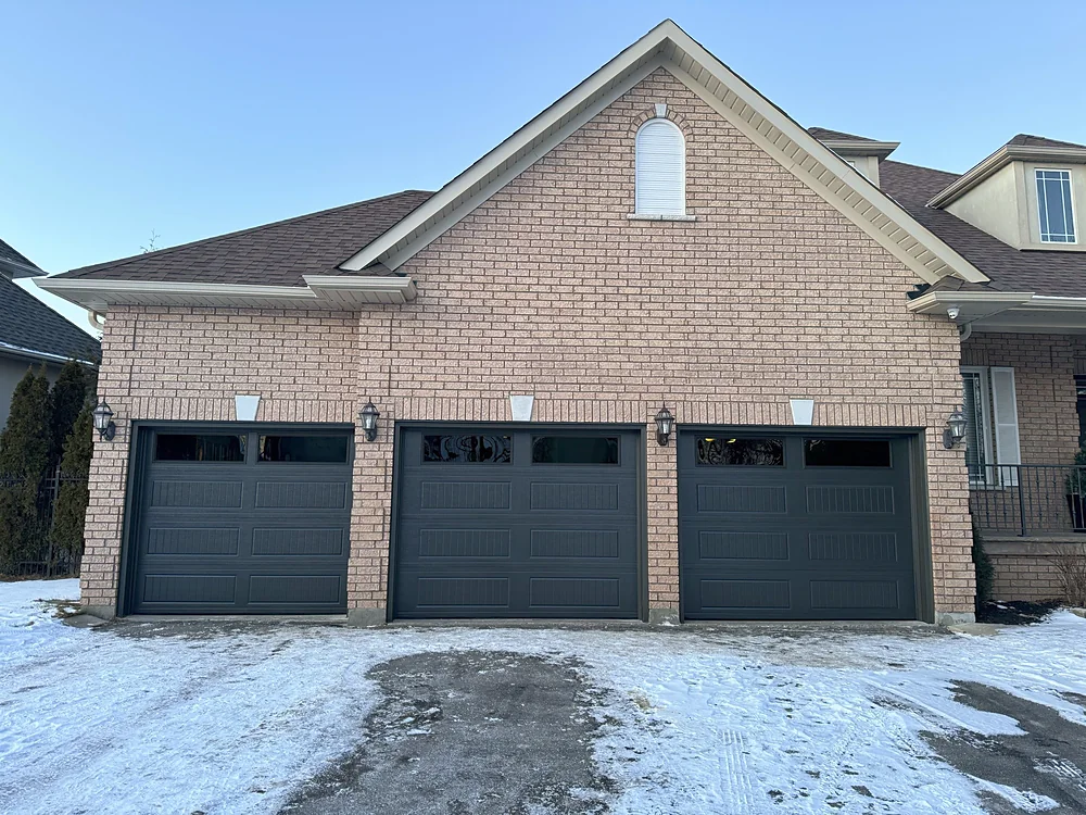 Black carriage-house garage doors with windows on a home in Vaughan