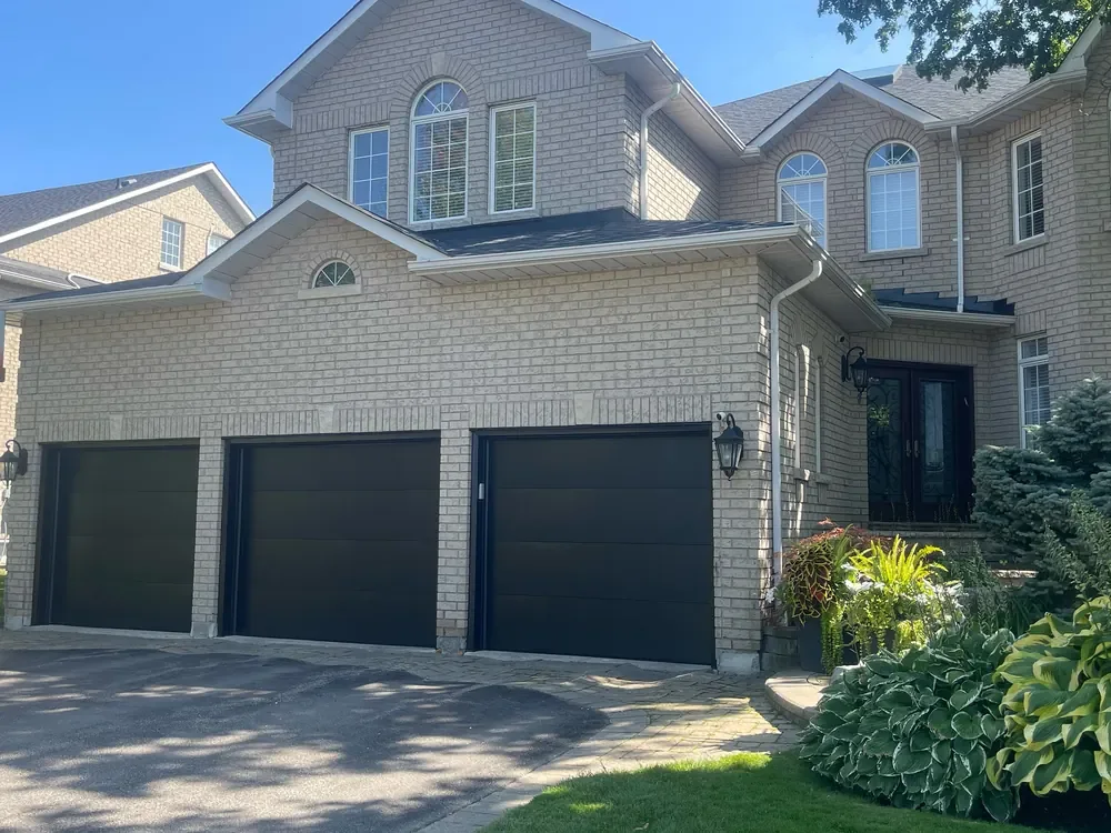 Black modern flush garage doors on a home in Vaughan