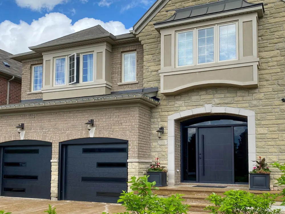 Black modern flush garage doors with slim glass strips on a home in Whitby