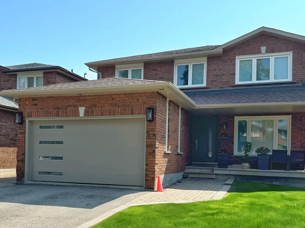 Sandstone Vog garage door with slim glass strips on a home in Burlington