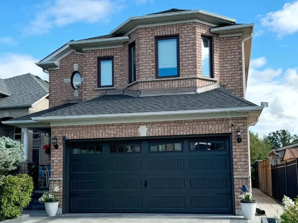 Black carriage-house garage door with windows on a home in Etobicoke