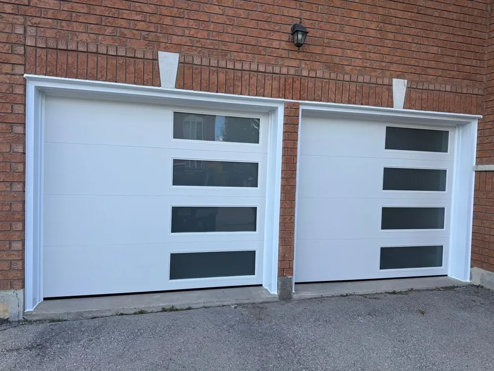 White modern flush garage doors with windows on a home in Milton