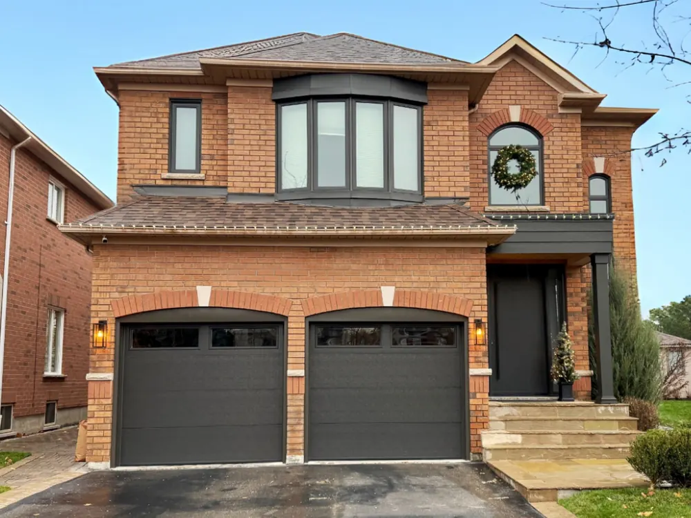 Dark brown modern flush garage doors with windows on a home in Whitby