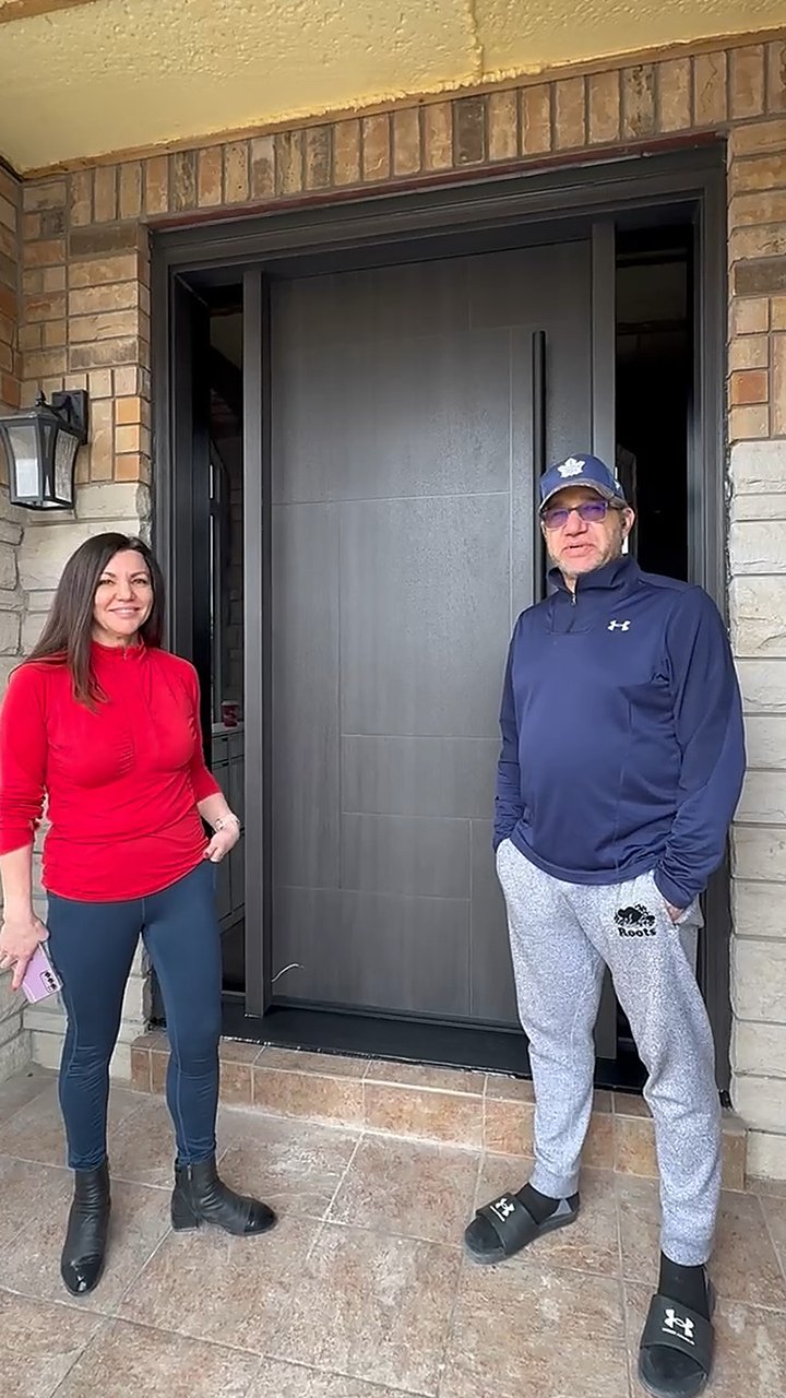 Garage Door Beasts customers outside their new dark modern entry door in Vaughan
