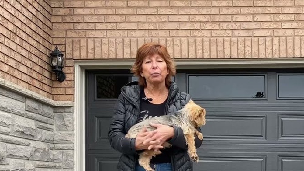 Garage Door Beasts customer holding her dog outside her new garage door in Vaughan