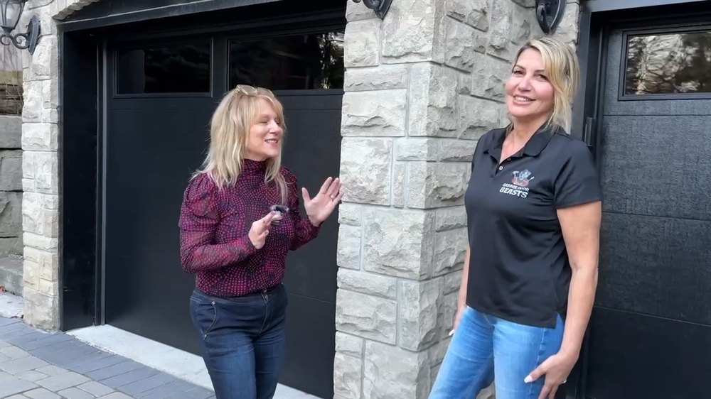 Garage Door Beasts customer outside her new black arched garage doors in Woodbridge